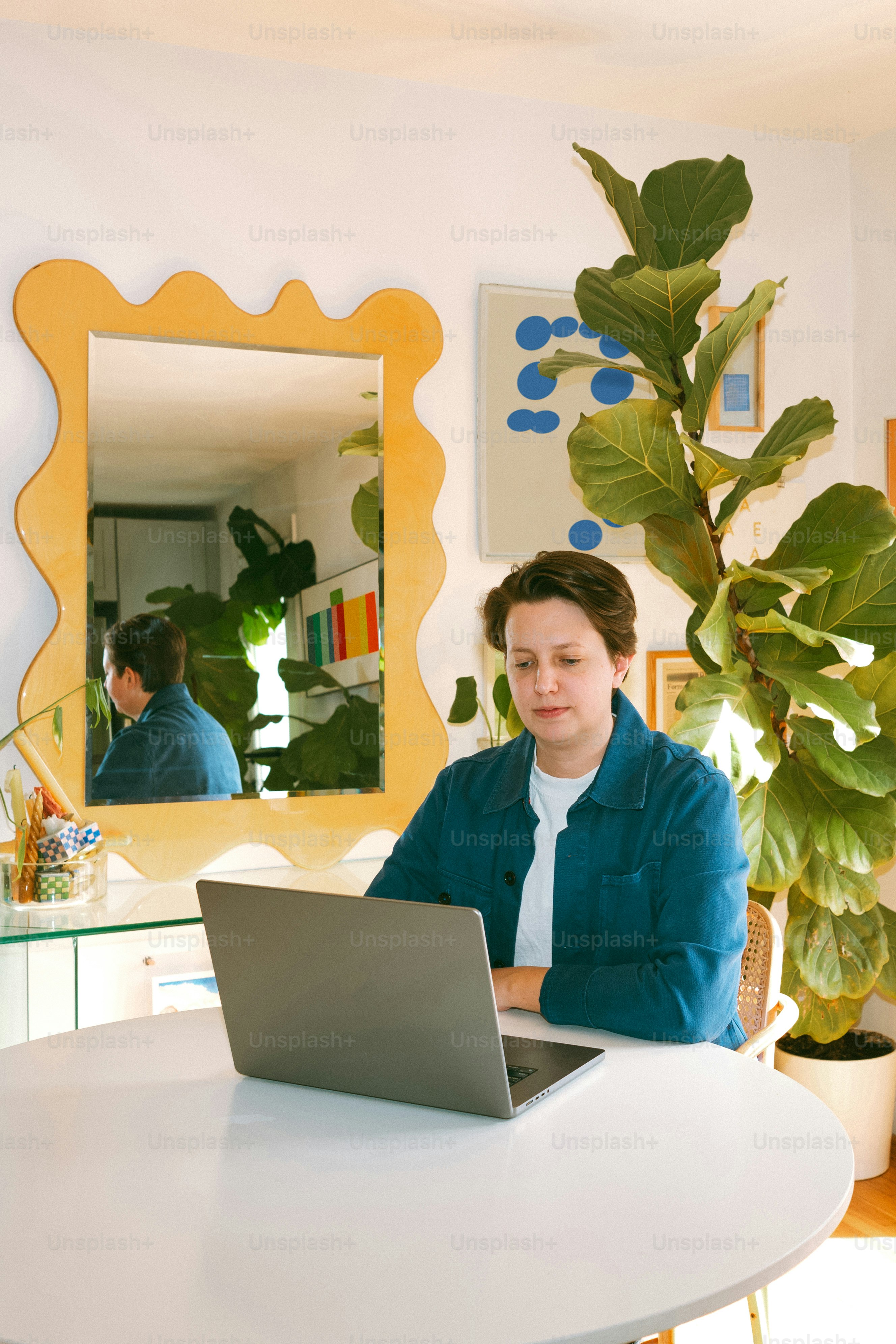 A woman sitting at a table using a laptop computer photo – Laptop Image ...