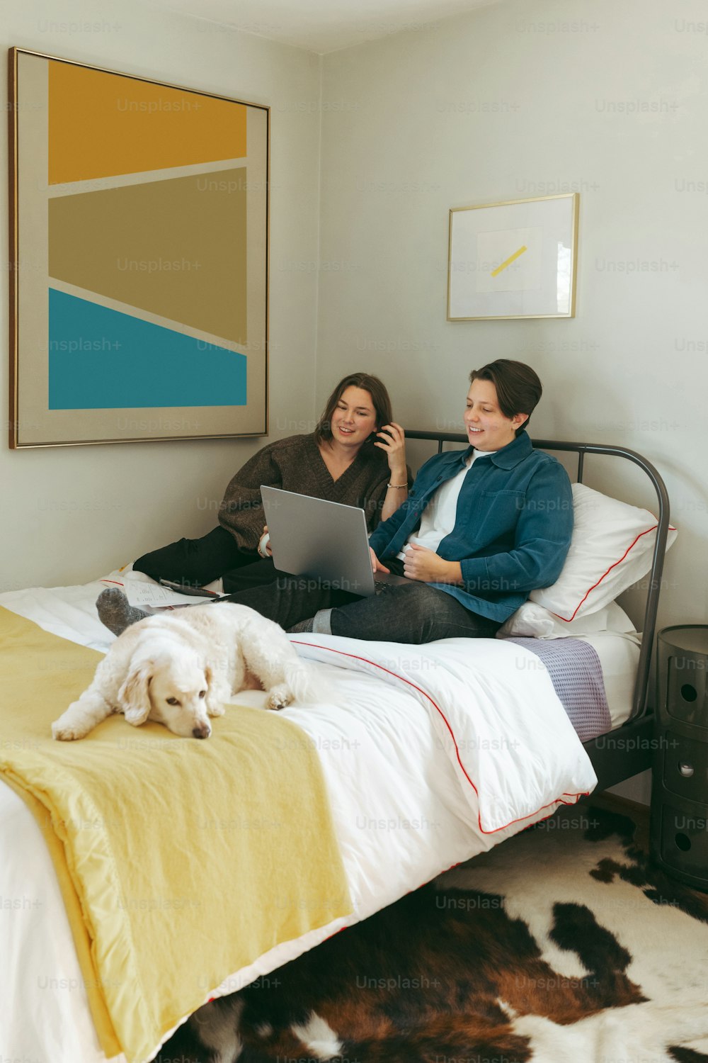 a couple of women sitting on top of a bed