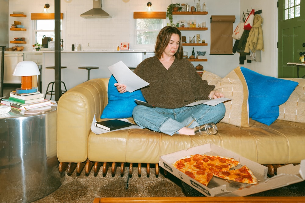 a woman sitting on a couch reading a book