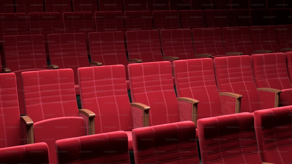 una fila de butacas rojas en un teatro