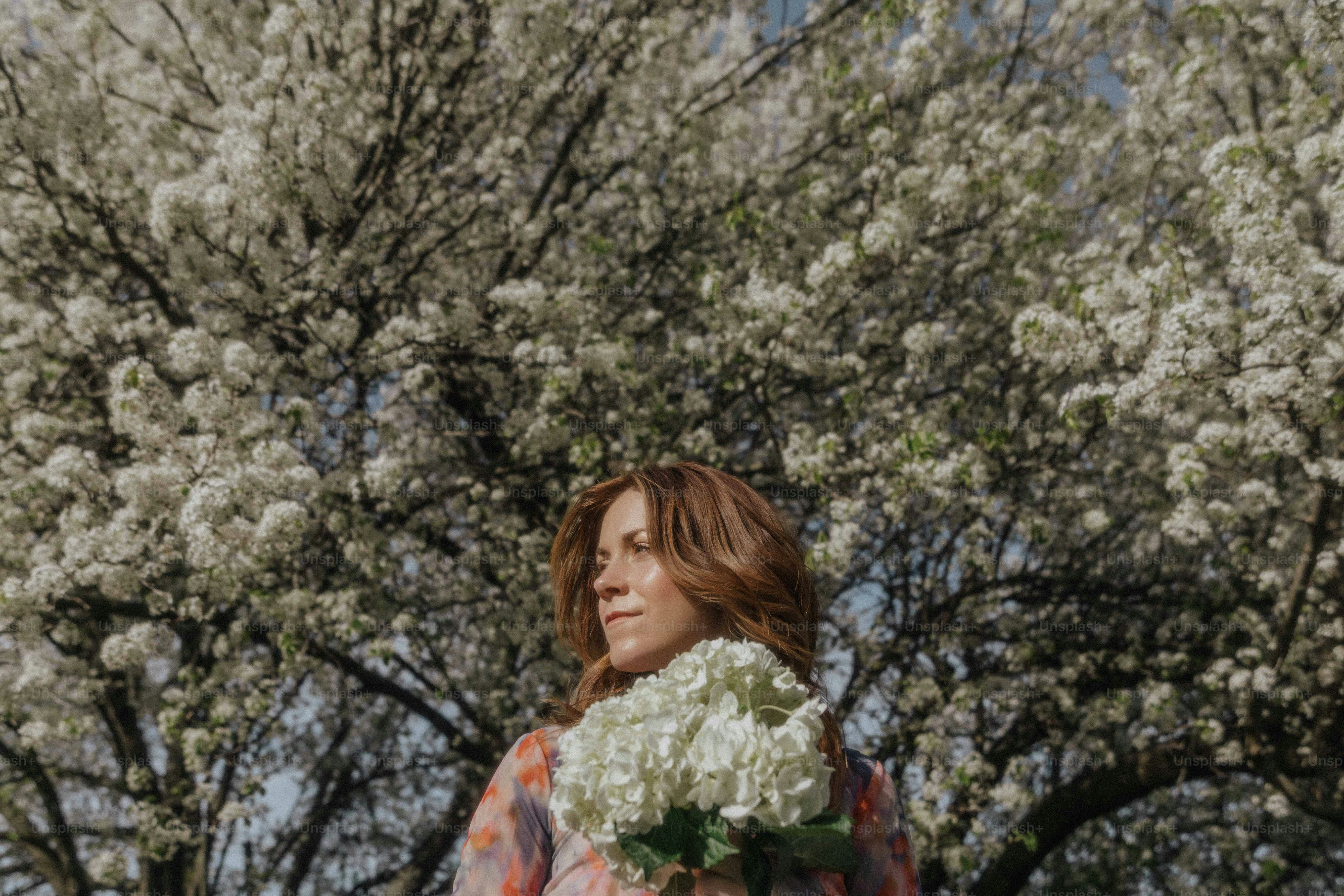 a woman holding a bouquet of white flowers