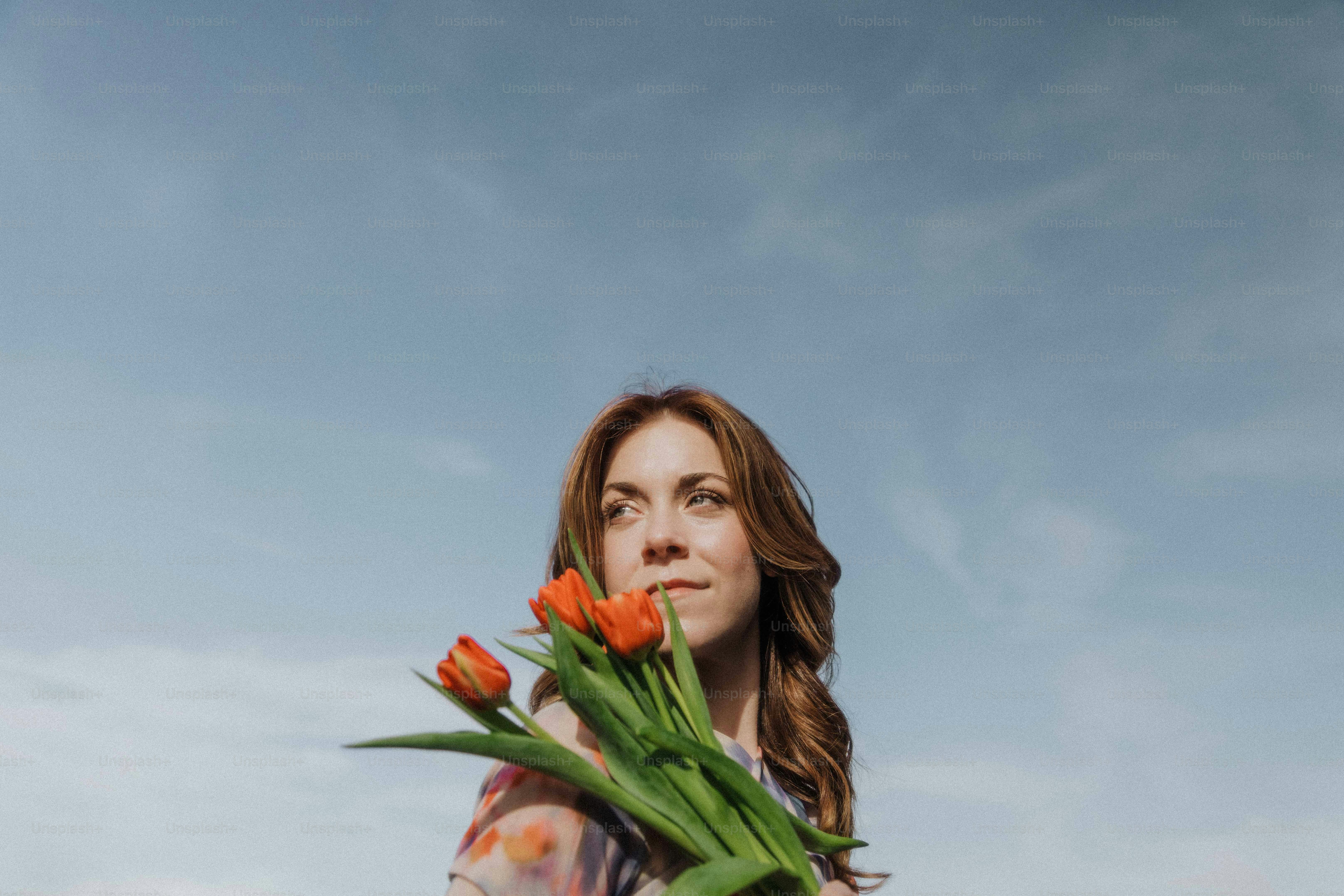a woman holding a bunch of flowers in her hands