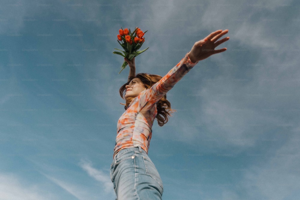 a woman holding a bunch of flowers up in the air