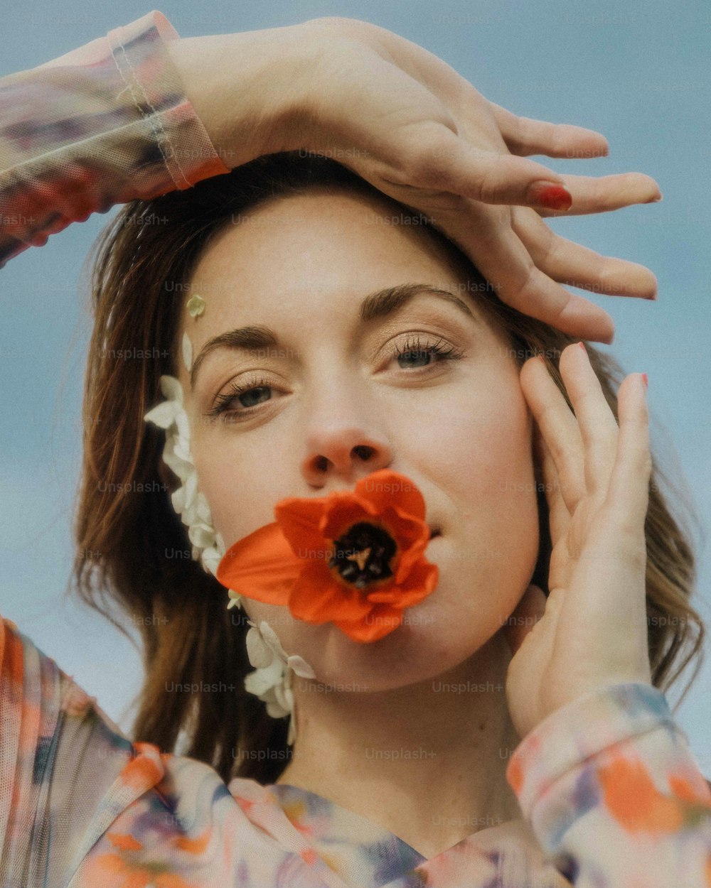 una donna che tiene un fiore davanti al suo viso