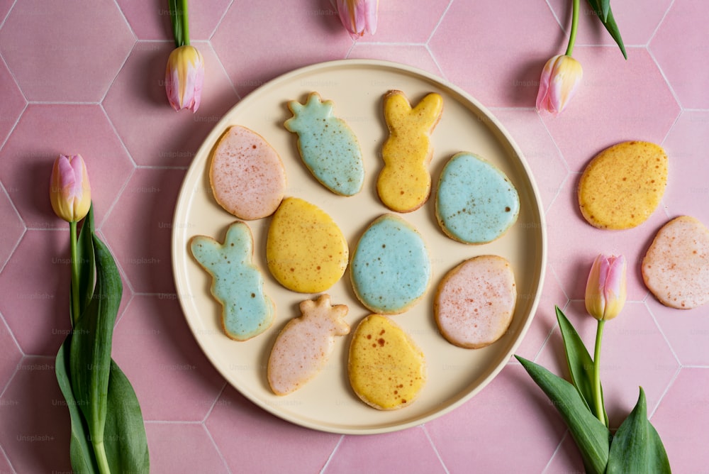 a plate of decorated cookies on a pink table