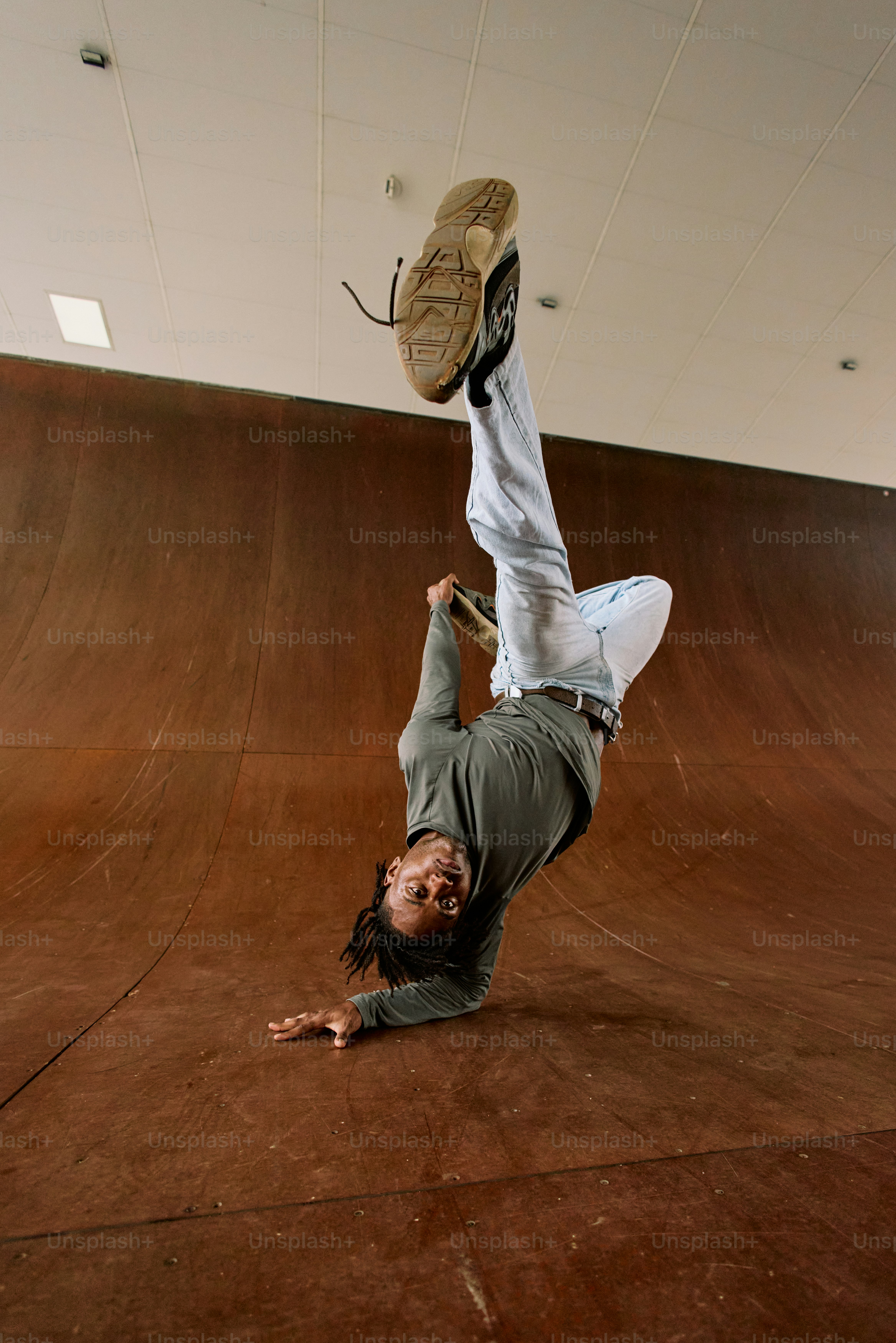 スケートボードで逆立ちをしている男性