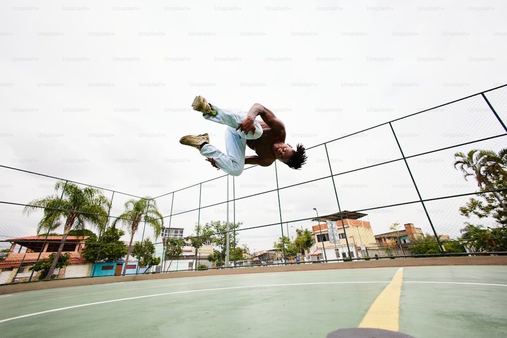 Un hombre volando por el aire mientras monta una patineta