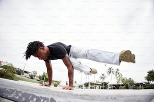 a man doing a hand stand on a skateboard