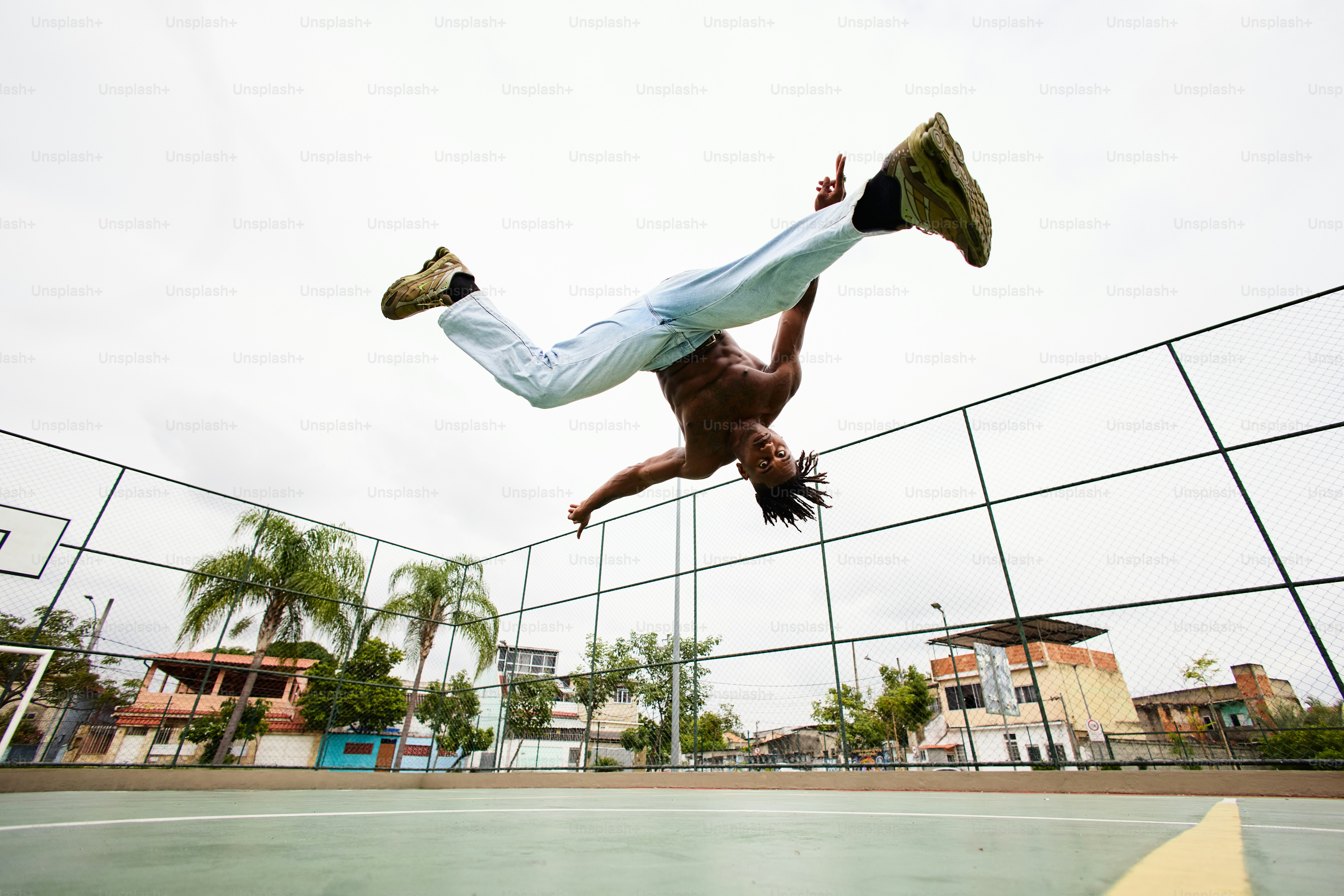 ein Mann macht einen Handstand auf einem Tennisplatz