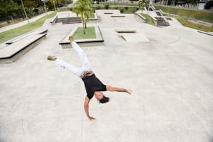 um homem fazendo um handstand em um skate em uma pista de skate