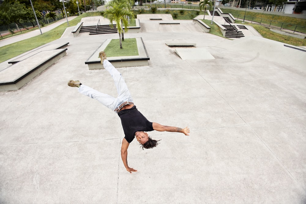 um homem fazendo um handstand em um skate em uma pista de skate