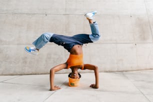 a man doing a handstand on a bucket