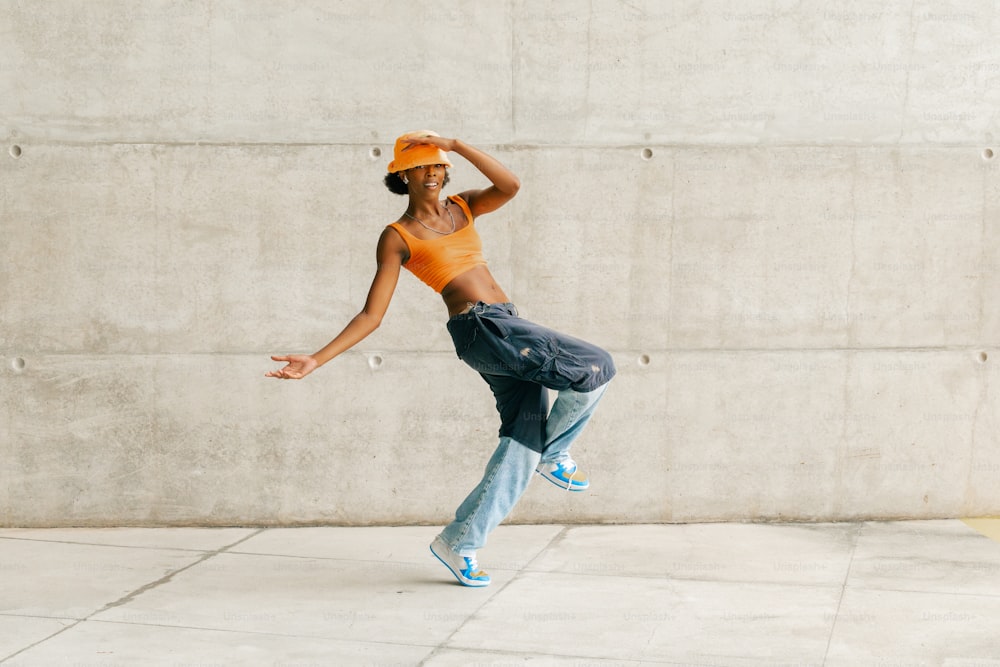 a woman in an orange shirt is doing a trick on a skateboard