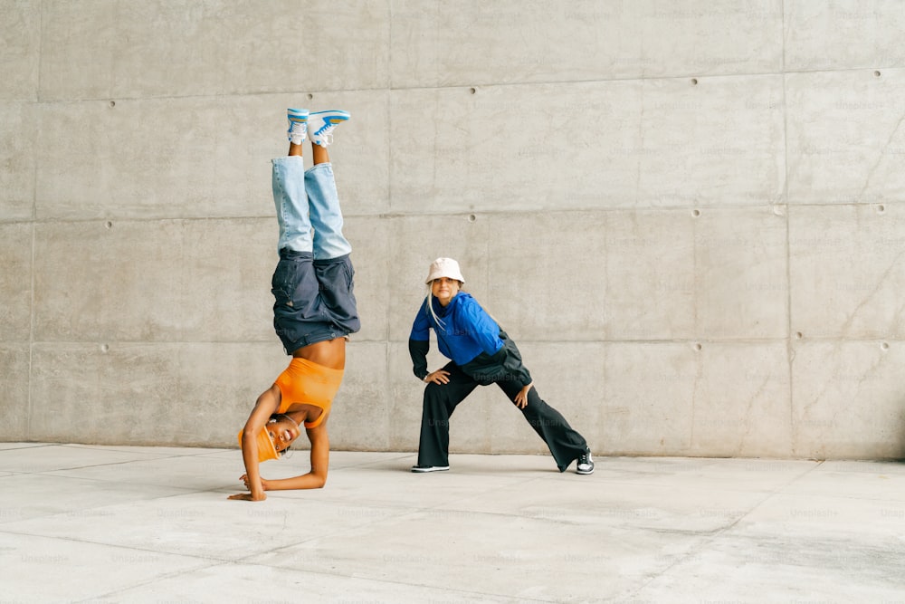 a man doing a handstand on top of a skateboard