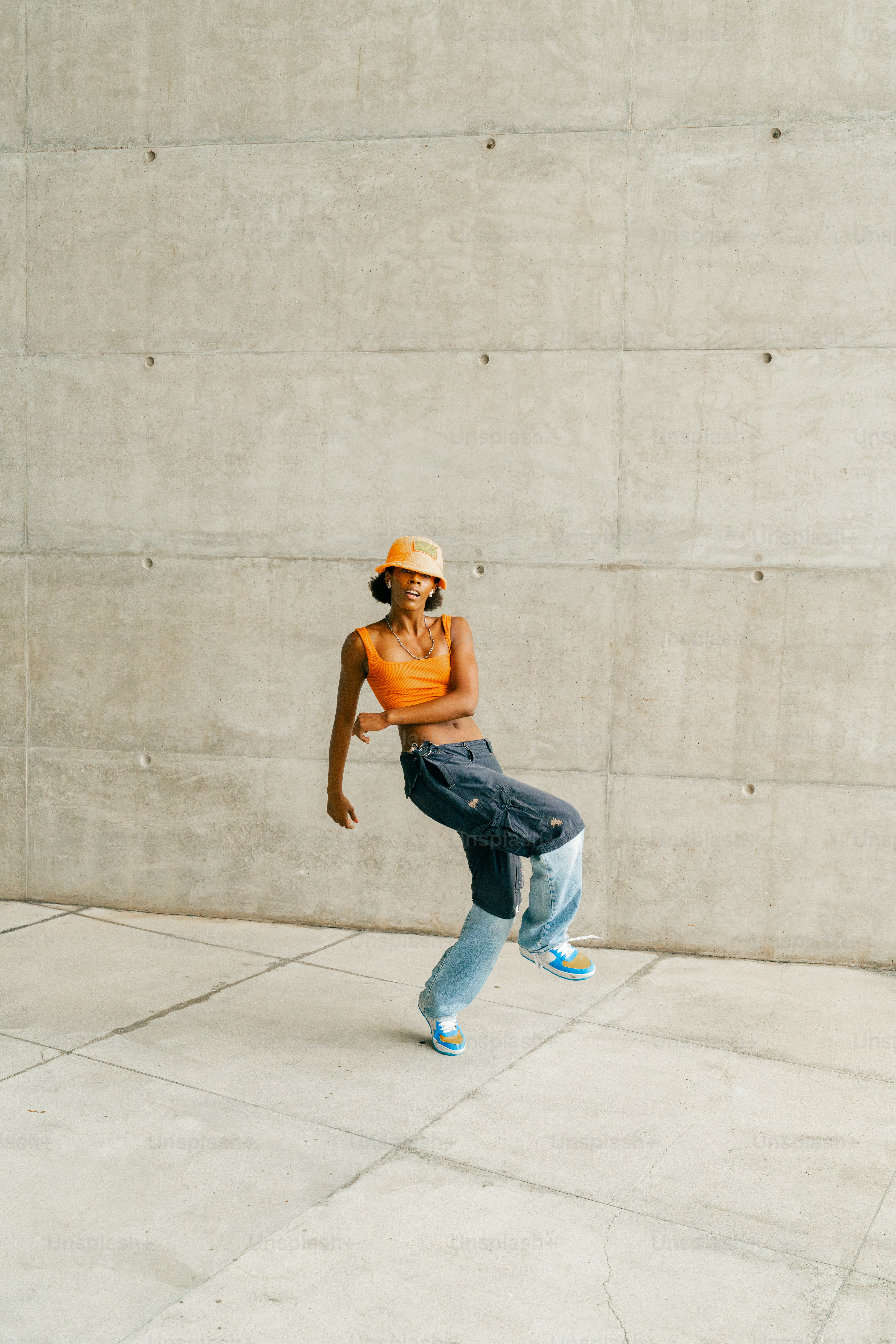 Eine Frau mit Hut tanzt auf einem Bürgersteig