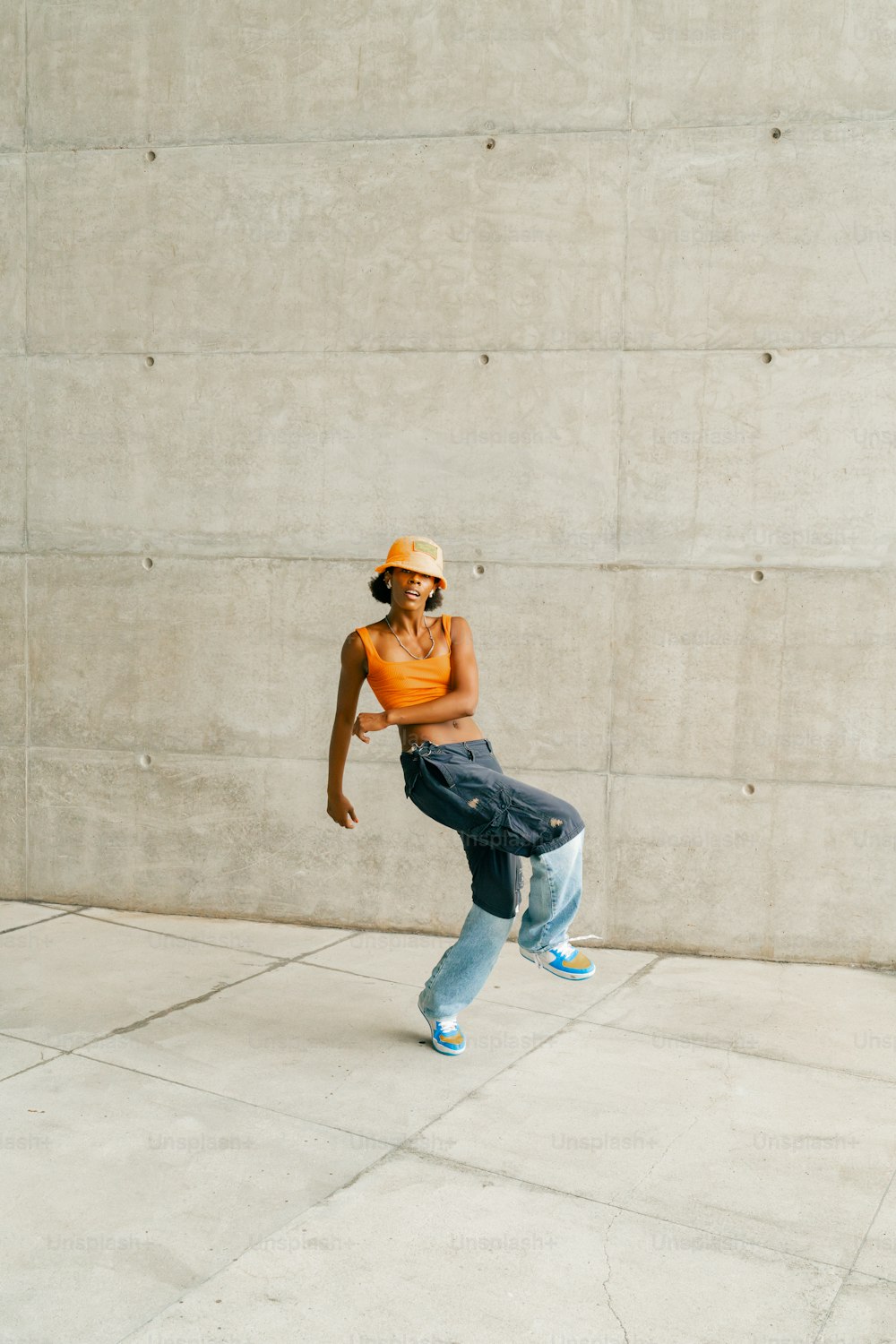 Eine Frau mit Hut tanzt auf einem Bürgersteig