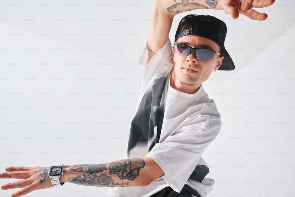 a man with a tattoo on his arm wearing a hat and sunglasses