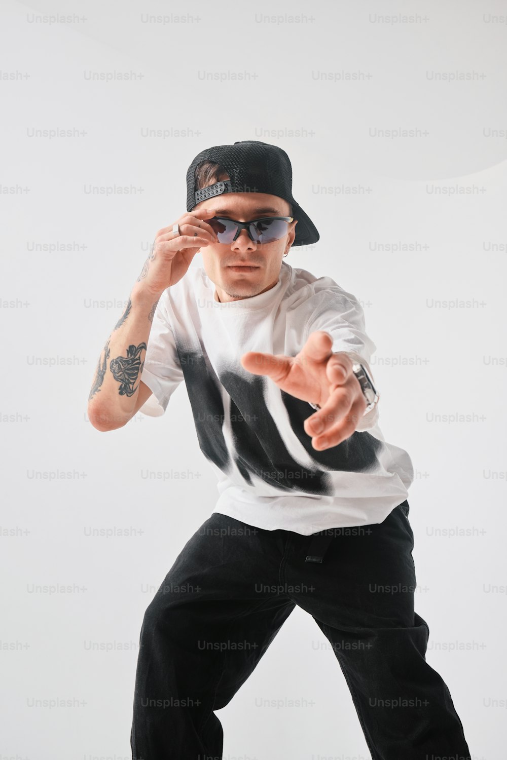 a man in a hat and sunglasses doing a dance move