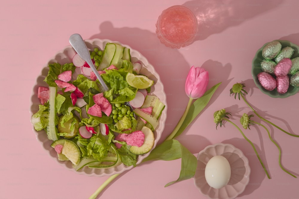 um prato de comida com flores e ovos em uma superfície rosa