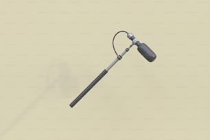 a metal pole with a long handle on a beige background
