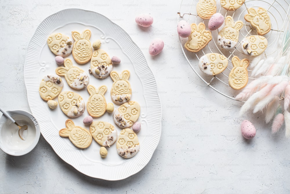 a white plate topped with cookies next to a bowl of candy