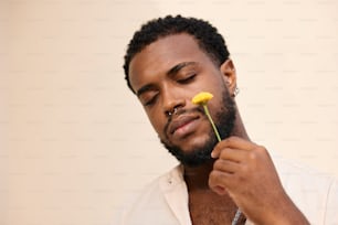 un hombre sosteniendo una flor en su mano derecha