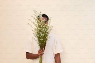 a man holding a bunch of flowers in his hands