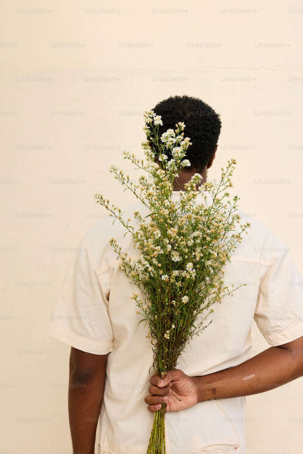 a man holding a bunch of flowers in his hands