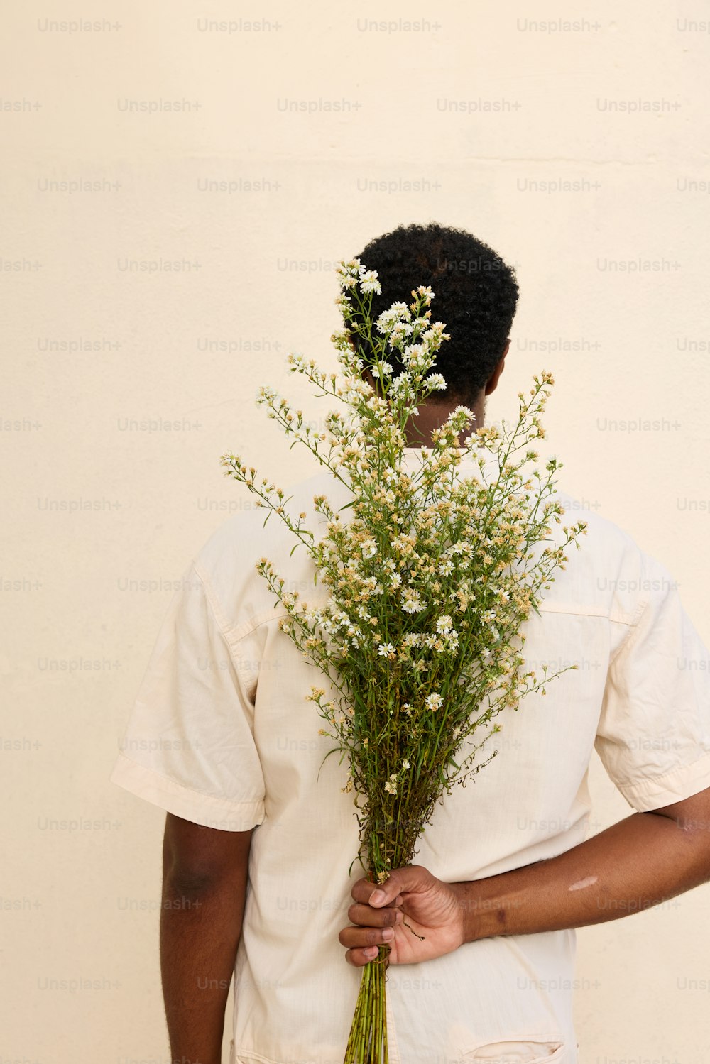 un homme tenant un bouquet de fleurs dans ses mains