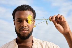 a man holding a flower up to his face