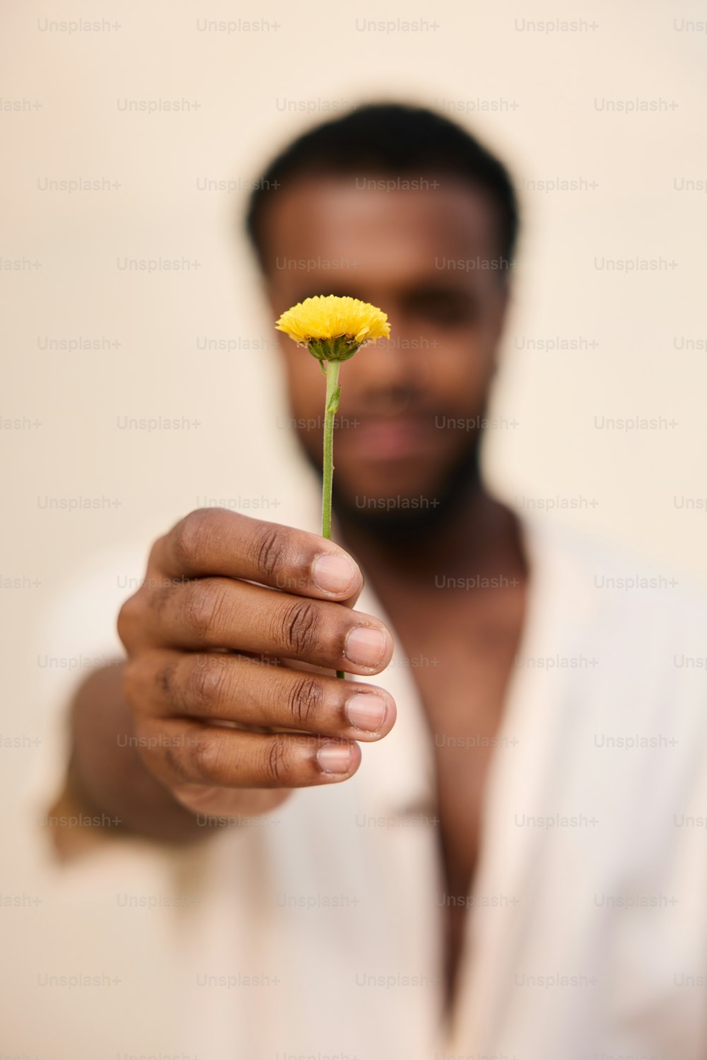 un hombre sosteniendo una flor amarilla en su mano