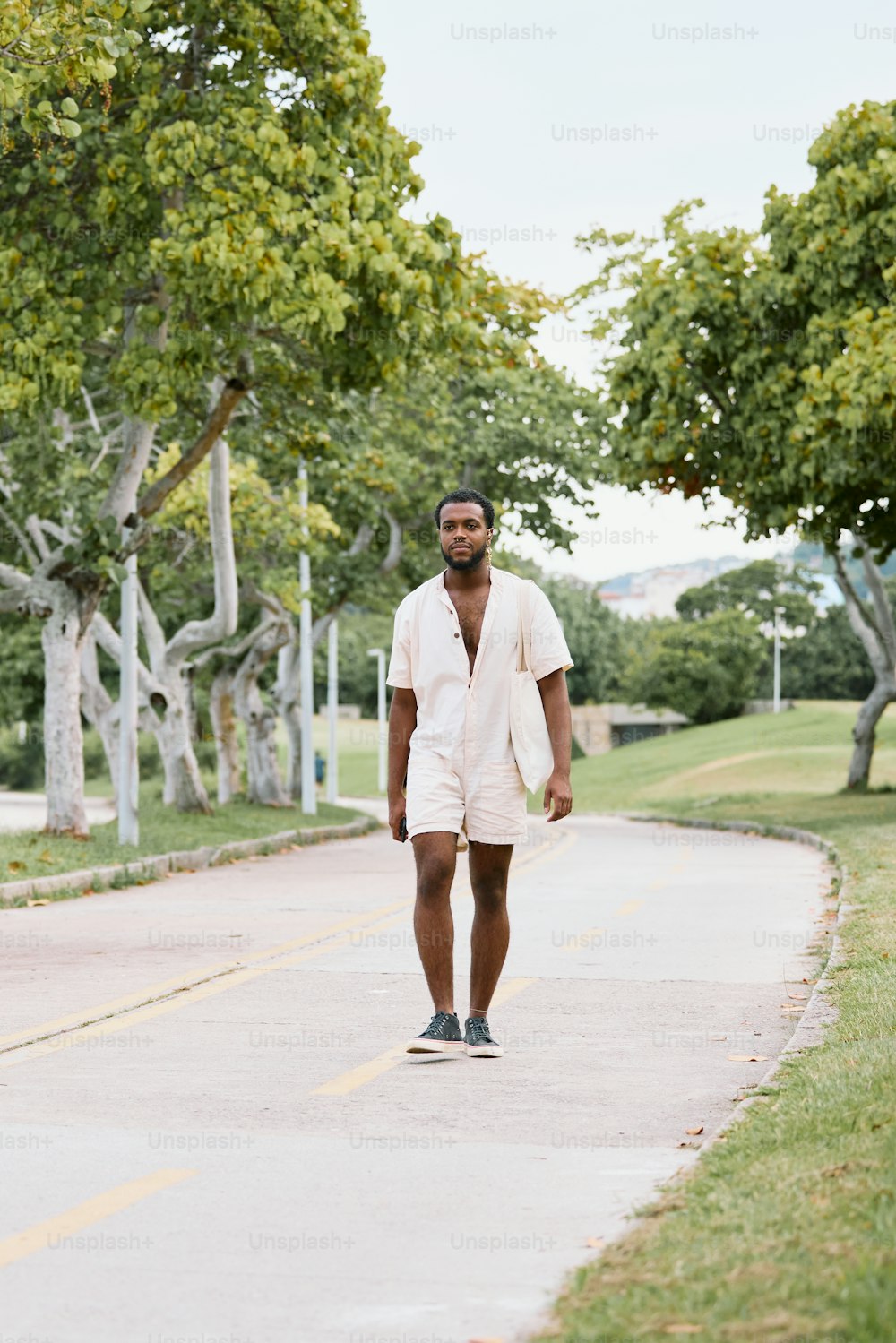 a man walking down a street with a skateboard