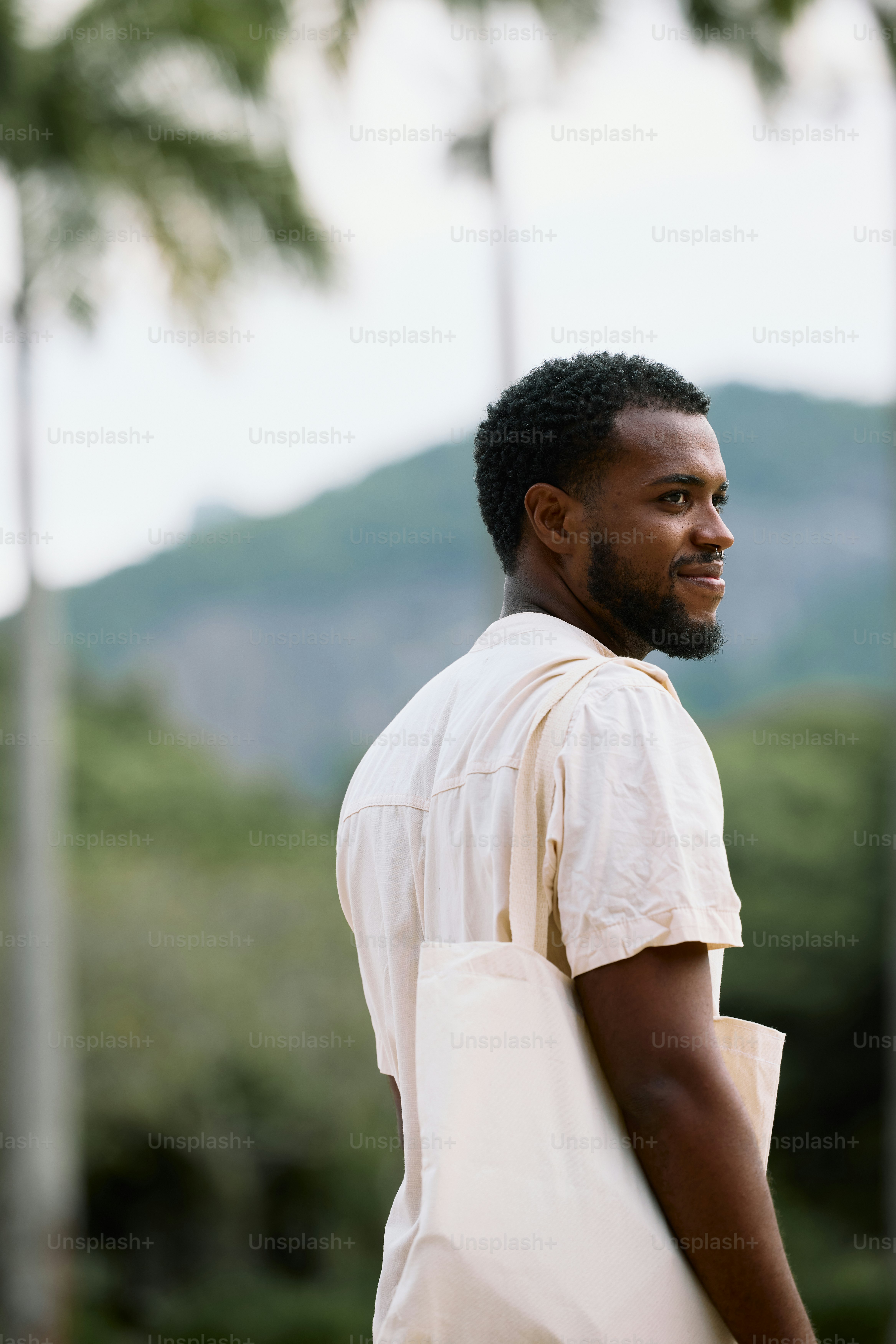 Ein Mann in einem weißen Hemd trägt eine weiße Tasche