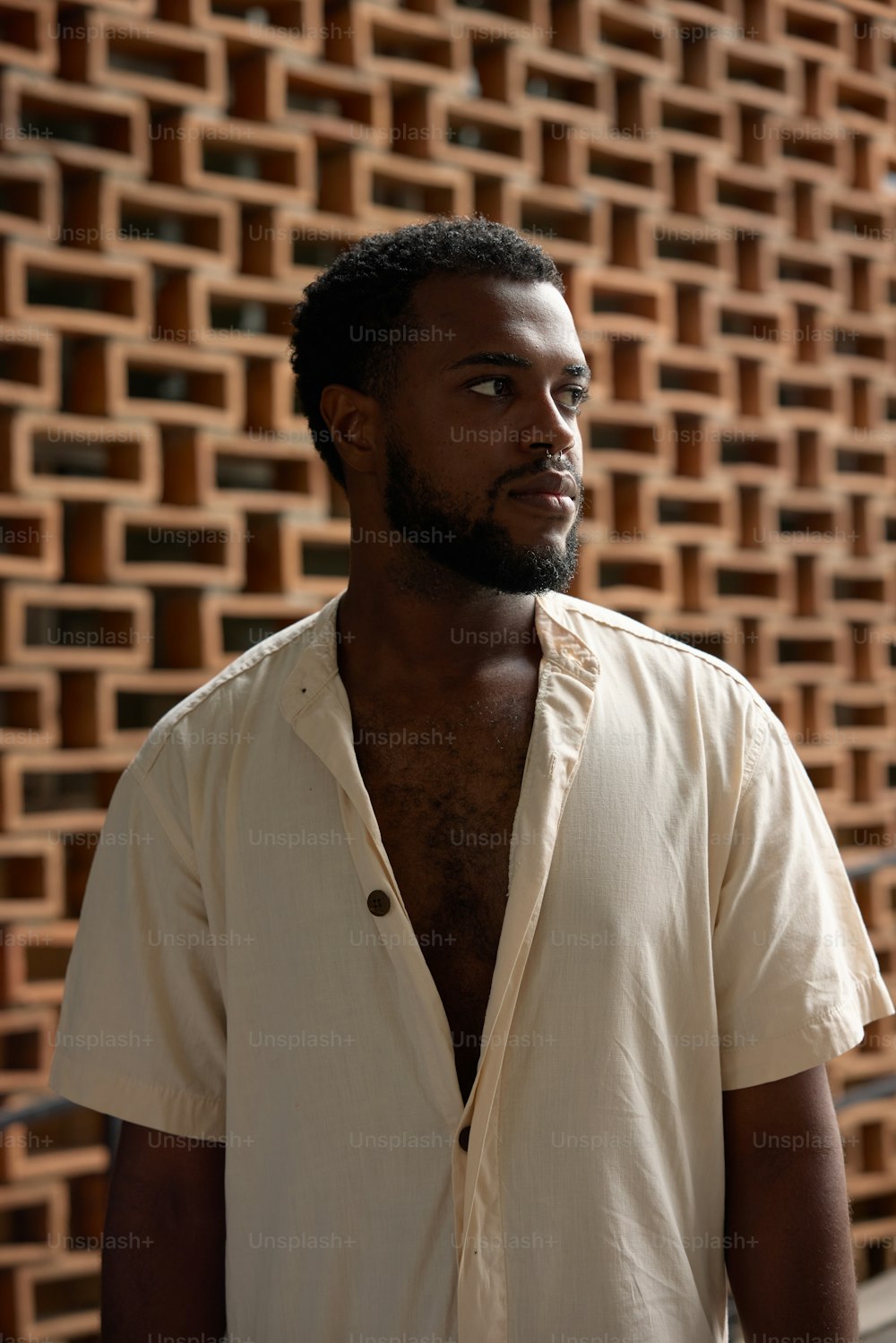 a man standing in front of a brick wall