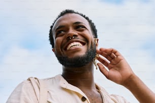 a man with a beard smiles while holding a pair of earrings