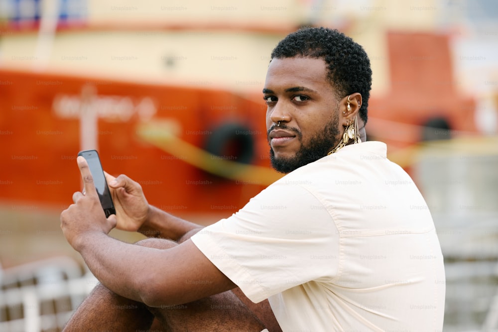 a man sitting on a bench holding a cell phone