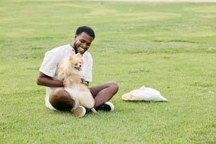 풀밭에 강아지와 함께 앉아 있는 남자