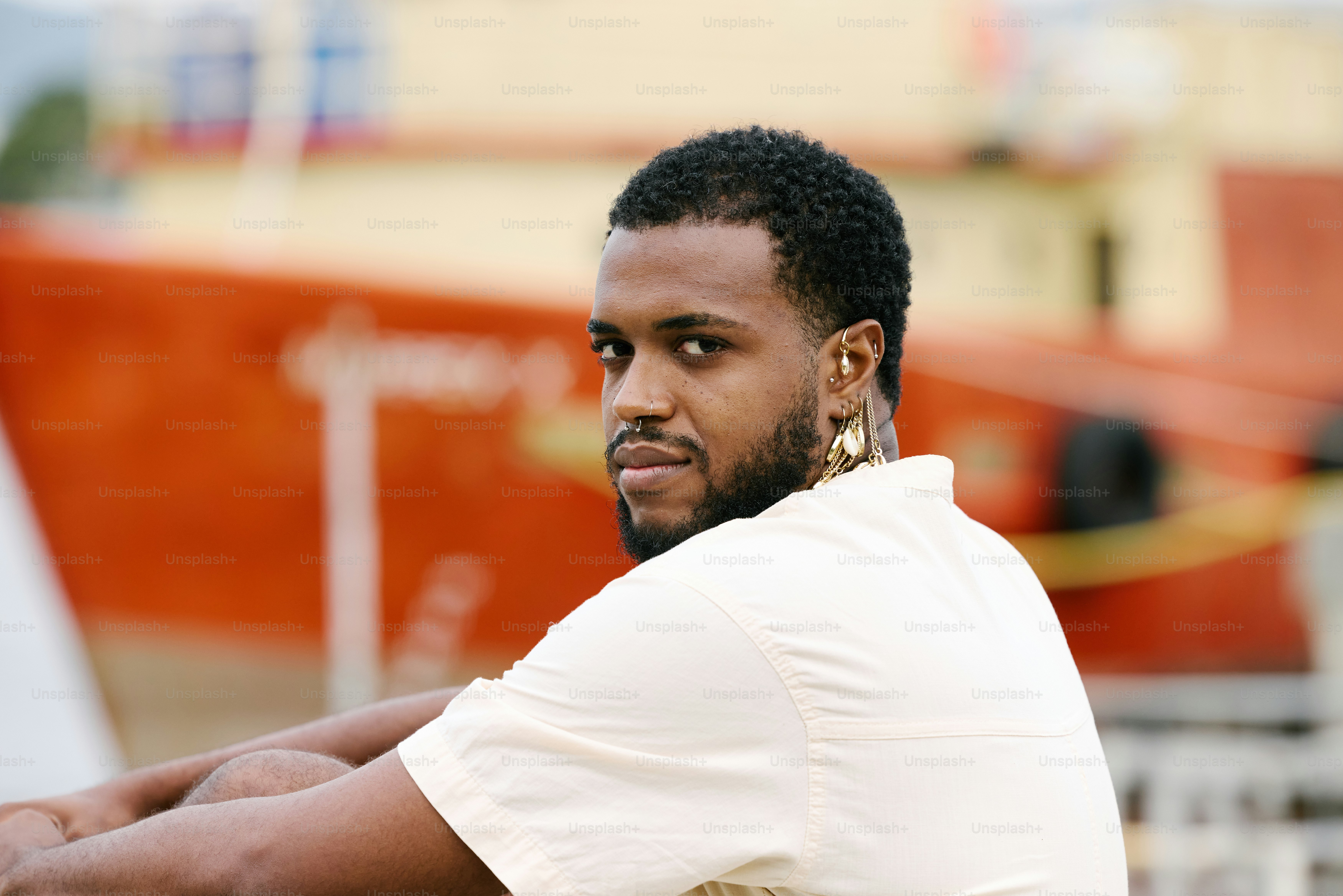 ein Mann sitzt auf einer Bank vor einem Boot