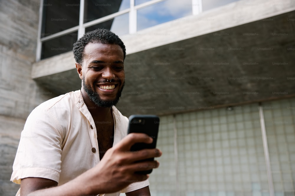Un hombre sonríe mientras mira su celular