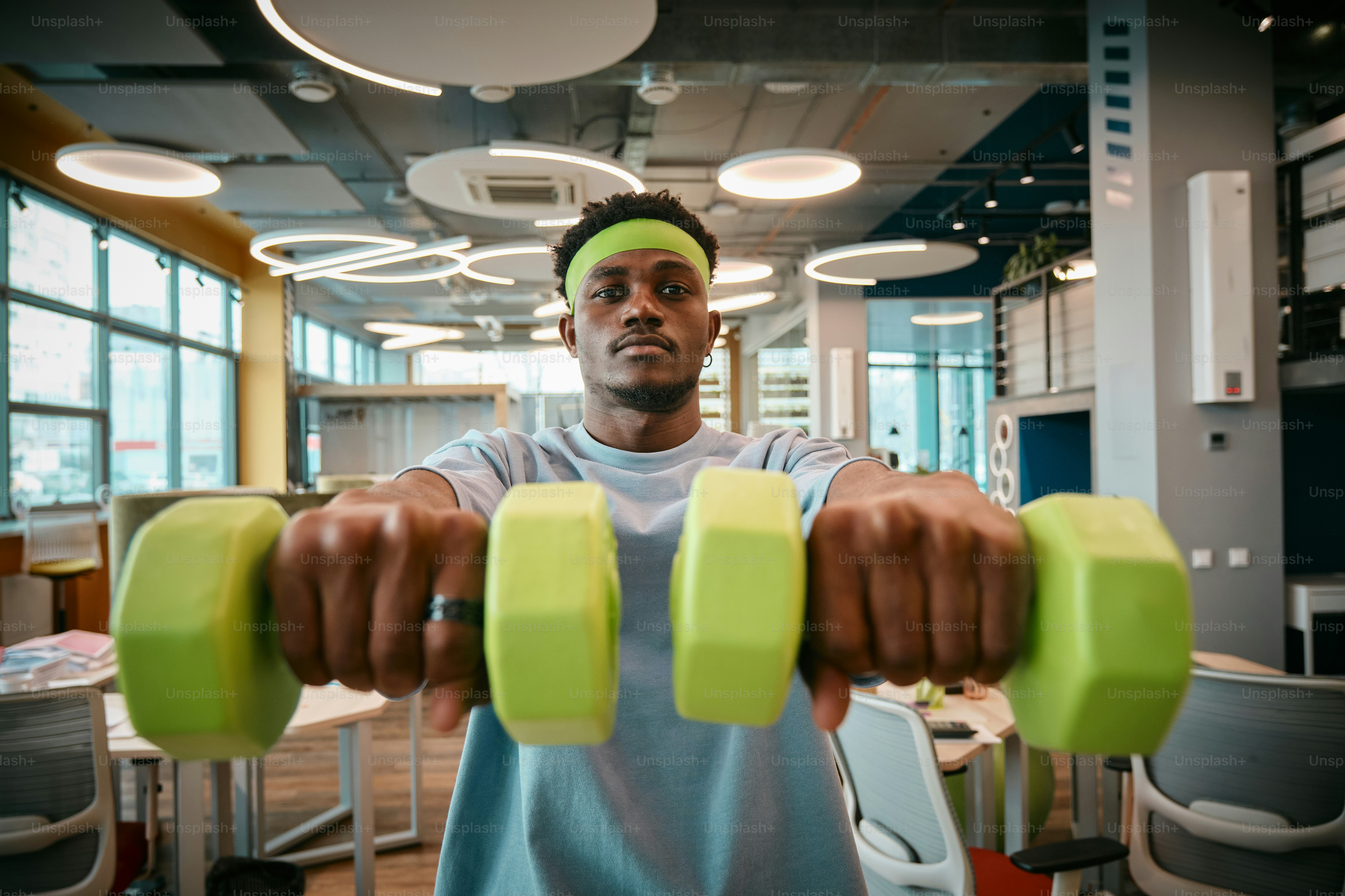 a man holding a pair of green dumbs