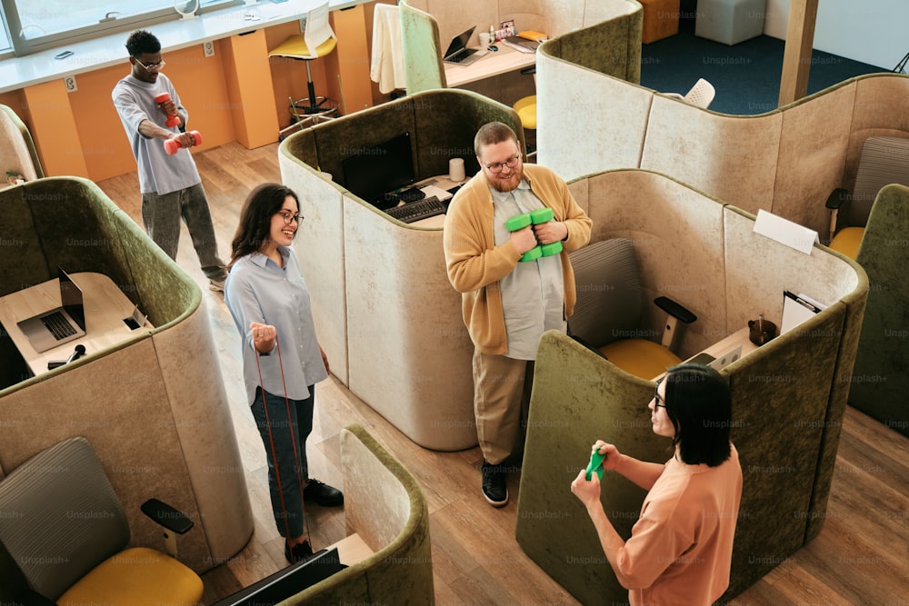 a group of people standing around a cubicle in an office