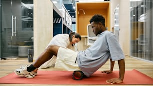 a man and a woman doing push ups on a mat