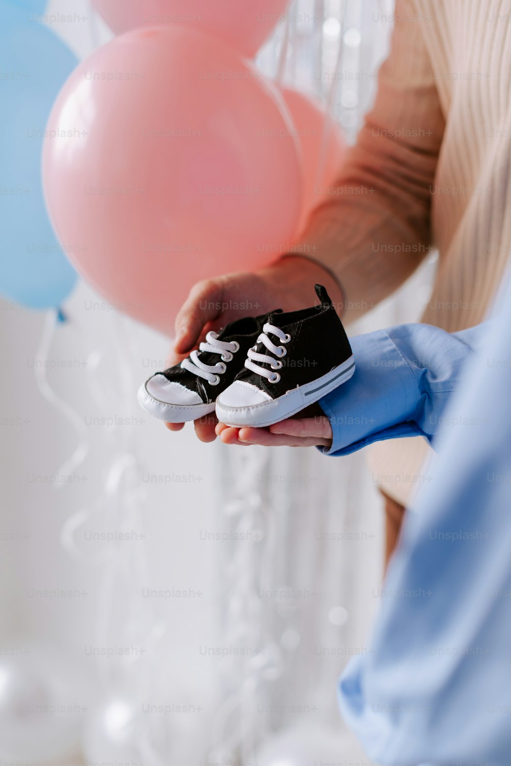 a person holding a pair of black and white shoes