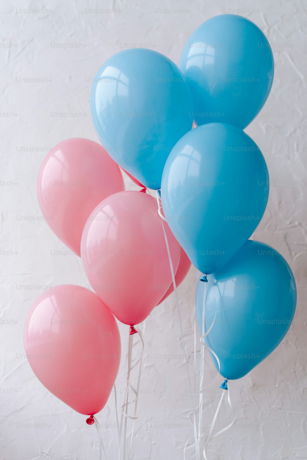 a bunch of blue and pink balloons on a stick