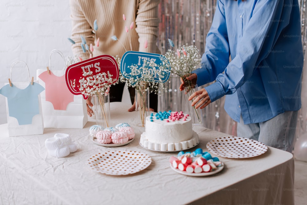 a man and woman standing next to a table with a cake