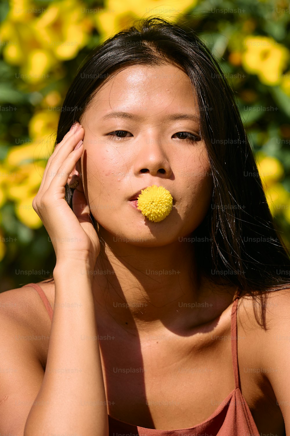 a woman with a yellow flower in her mouth