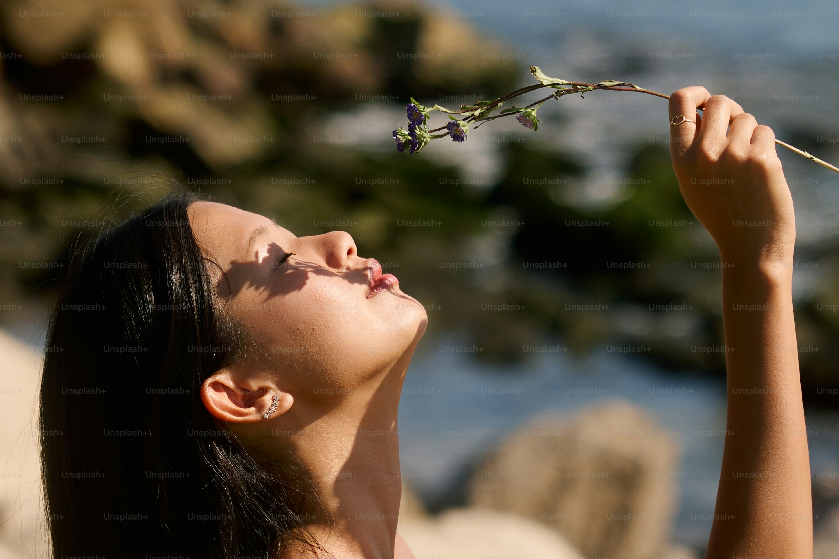 A woman holding a flower up to her face photo – Woman Image on Unsplash