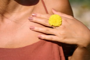 una mujer que lleva un anillo con una flor amarilla