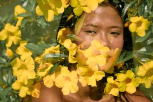 une femme avec des fleurs jaunes autour de son visage