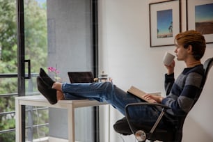 un homme assis sur une chaise buvant une tasse de café